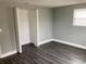 Bedroom with dark wood-look floors, neutral grey walls, and a closet at 5023 Queen Palm Dr, New Port Richey, FL 34652