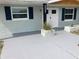 Inviting front entrance with fresh gray concrete, white front door and blue shutters at 5023 Queen Palm Dr, New Port Richey, FL 34652