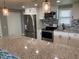 Modern kitchen with granite countertops, mosaic backsplash, and stainless steel appliances at 5023 Queen Palm Dr, New Port Richey, FL 34652