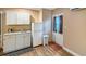 Kitchenette with white cabinets, granite counters, refrigerator, and exterior door at 5152 Panther Dr, Spring Hill, FL 34607