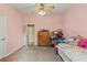Charming bedroom with pink walls, ceiling fan, and plush carpeting, perfect for creating a cozy retreat at 5216 Hope Ln, Spring Hill, FL 34606