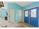 Inviting entryway featuring bright blue walls, light tile flooring, and decorative glass paneled double doors at 5216 Hope Ln, Spring Hill, FL 34606