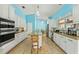 Open kitchen with white cabinets, stainless appliances, a center island, and granite countertops overlooking the living area at 5216 Hope Ln, Spring Hill, FL 34606