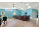 Open-concept living room with high ceilings, ample natural light, ceiling fans, and stylish wood-look floors at 5216 Hope Ln, Spring Hill, FL 34606