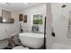 Bright bathroom featuring a modern tub, walk-in shower, decorative shelves, and ample natural light at 5234 Foxhall Ct, Weeki Wachee, FL 34607