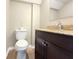 Compact bathroom with a brown vanity, granite countertop, and modern fixtures at 5713 Townhouse Dr # 5713, New Port Richey, FL 34652