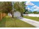 A backyard with a green lawn, driveway, and a white fence at 5753 2Nd N Ave, St Petersburg, FL 33710