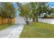 A spacious backyard with green lawn, driveway, and a white fence at 5753 2Nd N Ave, St Petersburg, FL 33710
