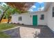 A backyard featuring a brick patio, a green door, and a partial shade structure on a sunny day at 5753 2Nd N Ave, St Petersburg, FL 33710