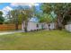A white single-story home with a green lawn and a wood fence on a sunny day at 5753 2Nd N Ave, St Petersburg, FL 33710