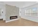 Modern living room with wood-look floors and a stylish stone accent wall with electric fireplace at 5753 2Nd N Ave, St Petersburg, FL 33710