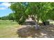 Charming home exterior with mature trees, a fenced yard, and welcoming front entrance at 7089 Goodway, Brooksville, FL 34602