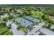 Aerial view of tennis courts surrounded by trees, landscaping, and ample parking at 7367 Willow Brook Dr, Spring Hill, FL 34606