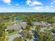 Aerial view of a golf course and country club featuring a pool, tennis courts and parking at 7367 Willow Brook Dr, Spring Hill, FL 34606