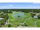 Picturesque aerial view of a golf course, featuring a pond, lush greens, and surrounding trees at 7367 Willow Brook Dr, Spring Hill, FL 34606