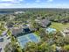 An aerial view showcasing tennis courts, a pool, and other community features, surrounded by lush greenery at 7367 Willow Brook Dr, Spring Hill, FL 34606