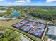 Overhead view of multiple tennis courts in a community with well-maintained landscaping at 7367 Willow Brook Dr, Spring Hill, FL 34606