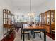 Elegant dining area featuring stylish light fixture and hardwood floors adjacent to living area at 7367 Willow Brook Dr, Spring Hill, FL 34606