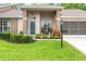 Charming home featuring a blue front door, lovely front yard, and a screened 2 car garage at 7367 Willow Brook Dr, Spring Hill, FL 34606