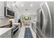 Eat-in kitchen boasts stainless steel appliances, gray cabinets, tile flooring, and natural light at 7367 Willow Brook Dr, Spring Hill, FL 34606