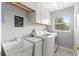 Bright laundry room with sink, washer, dryer, window, and upper cabinets at 7367 Willow Brook Dr, Spring Hill, FL 34606