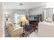 Inviting living room with a cozy sofa, large window, ceiling fan, and modern decor at 7367 Willow Brook Dr, Spring Hill, FL 34606
