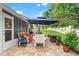 Relaxing brick patio featuring comfortable seating under a large umbrella and lush landscaping at 7367 Willow Brook Dr, Spring Hill, FL 34606