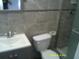 Cozy bathroom featuring a toilet, vanity, and tile flooring at 7419 E Comanche Ave, Tampa, FL 33610