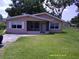 Charming single-story home featuring a screened front porch, well-maintained lawn, and inviting curb appeal at 7419 E Comanche Ave, Tampa, FL 33610