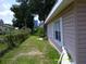 The side yard features a grassy lawn, chain link fence and mature trees at 7419 E Comanche Ave, Tampa, FL 33610