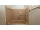 Bathroom with pink tile, tub, hand rails, shower, and shower head at 7501 Woodbox Row, Hudson, FL 34667