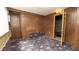Bedroom with wood paneling and unusual carpet, showing access to another room at 7501 Woodbox Row, Hudson, FL 34667
