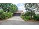 Charming home featuring a garage, driveway, and mature landscaping for added privacy and curb appeal at 7501 Woodbox Row, Hudson, FL 34667