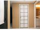 Hallway view with access to a bathroom featuring a white door with square grids at 7501 Woodbox Row, Hudson, FL 34667
