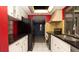 A well-lit kitchen featuring stainless steel appliances, black countertops, and ample cabinet space at 7501 Woodbox Row, Hudson, FL 34667