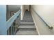 Carpeted staircase with blue railings leading to the upper level at 7501 Woodbox Row, Hudson, FL 34667