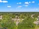 A tranquil aerial view of a residential neighborhood nestled among lush green trees and a scenic pond at 7512 Heather Walk Dr, Weeki Wachee, FL 34613