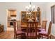 Dining room with hardwood floors, wooden table, chairs, and a built-in china cabinet, adjacent to the kitchen at 7512 Heather Walk Dr, Weeki Wachee, FL 34613