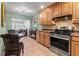 Open-concept kitchen with stainless steel appliances, granite countertops, and views into the adjacent dining and living areas at 7512 Heather Walk Dr, Weeki Wachee, FL 34613