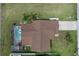 An aerial shot of the home features a screened-in pool, brick chimney, and well kept landscaping at 7520 Mako Dr, Hudson, FL 34667