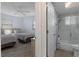 Bathroom with shower/tub combination and glass door, connecting to a bedroom with two beds at 7520 Mako Dr, Hudson, FL 34667