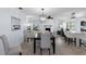 Elegant dining area with a modern chandelier, wood-look tile flooring, and plenty of seating at 7520 Mako Dr, Hudson, FL 34667