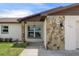 Welcoming entrance featuring stone accents, a well-lit porch, and manicured landscaping at 7520 Mako Dr, Hudson, FL 34667