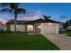 Charming single-story home featuring a well-maintained lawn and a classic stone facade detail at sunset at 7520 Mako Dr, Hudson, FL 34667