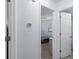 Hallway with white walls leads to a bedroom, featuring a thermostat, and hardwood floors at 7520 Mako Dr, Hudson, FL 34667