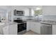 Modern kitchen with stainless steel appliances, granite countertops, and white cabinetry at 7520 Mako Dr, Hudson, FL 34667