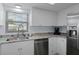 Bright kitchen featuring white cabinets, stainless steel appliances, and granite countertops at 7520 Mako Dr, Hudson, FL 34667