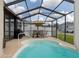 Relaxing pool area with shaded dining, grill, and well-maintained enclosure for outdoor enjoyment and privacy at 7520 Mako Dr, Hudson, FL 34667