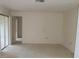 Spacious bedroom with sliding glass door, neutral carpet, and light walls, offering a versatile living space at 7600 St. Andrews Blvd # 7600, Weeki Wachee, FL 34613