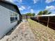 Backyard with gravel and grass leading to a screened-in pool at 7719 Gaston Dr, Port Richey, FL 34668